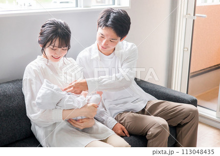 赤ちゃんを抱く夫婦・ママとパパ・新生児（子育て・育児） 113048435