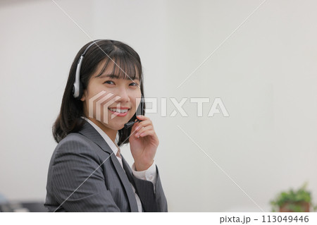 ヘッドセットに手を添えるオペレーター女性_1 ヘッドセットに手を添えるオペレーター女性_1 113049446