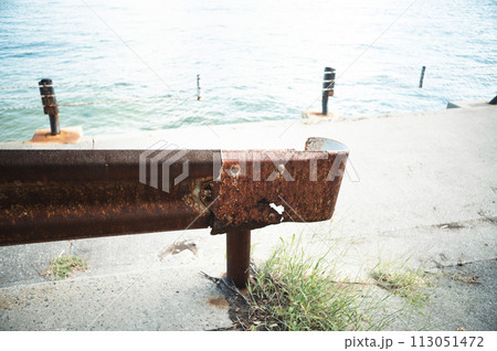 瀬戸内海の島の海沿いの道路のさびたガードレール 113051472