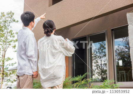 マイホームを指差す夫婦・家族（不動産・注文住宅・新築） 113053952