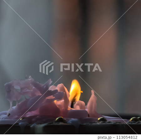 Burning candle on a wooden table. Selective focus. Toned. Burning candle on a wooden table. Selective focus. Toned. 113054812