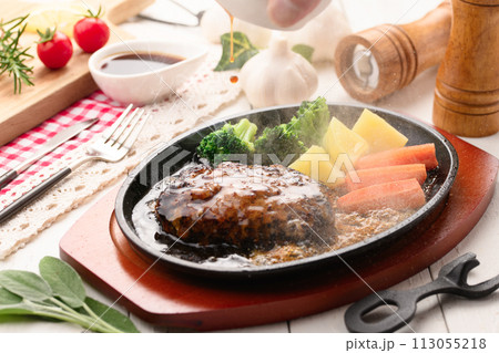 鉄板で焼き上げた熱々のハンバーグステーキ 113055218