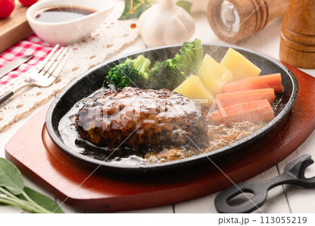 鉄板で焼き上げた熱々のハンバーグステーキ 113055219