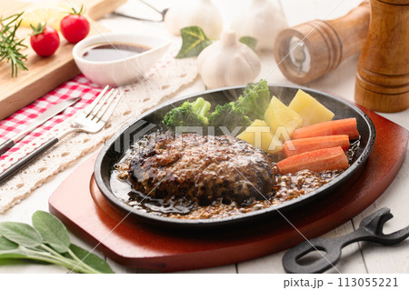 鉄板で焼き上げた熱々のハンバーグステーキ 113055221