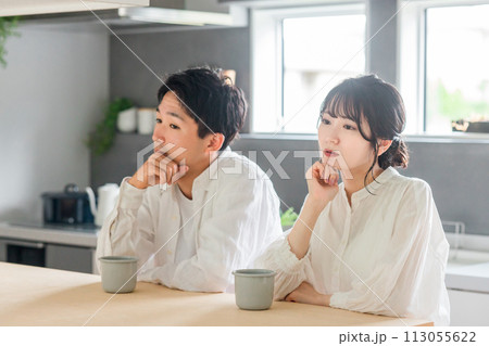 ダイニングに座る冷めた表情の若い夫婦・カップル(夫婦関係・倦怠期・マンネリ・仮面夫婦・夫婦喧嘩) ダイニングに座る冷めた表情の若い夫婦・カップル(夫婦関係・倦怠期・マンネリ・仮面夫婦・夫婦喧嘩) 113055622