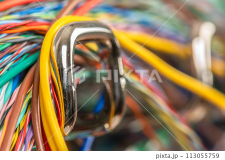 Colored electrical cable on hook of organizer, macro view with blurred background Colored electrical cable on hook of organizer, macro view with blurred background 113055759