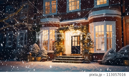 Christmas in the countryside manor, English country house mansion decorated for holidays on a snowy winter evening with snow and holiday lights, Merry Christmas and Happy Holidays 113057016