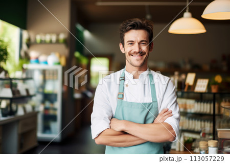 Happy man in apron standing at a modern shop, business owner or employee 113057229