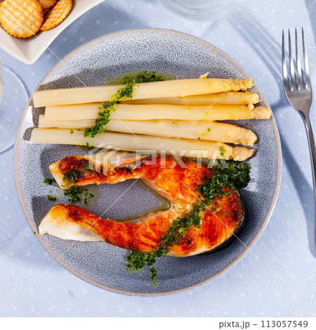 Roasted salmon steak and white asparagus on plate 113057549