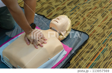CPR First Aid Training with CPR dummy in the class. Demonstrating chest compressions concept. 113057569