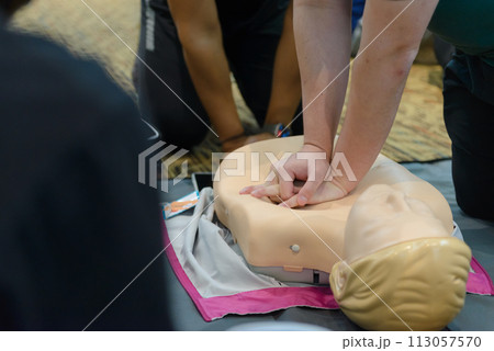 CPR First Aid Training with CPR dummy in the class. Demonstrating chest compressions concept. 113057570