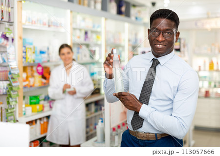 Man standing in drugstore Man standing in drugstore 113057666