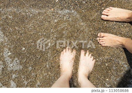 A man walks barefoot on the sand on the beach. A man walks barefoot on the sand on the beach. 113058686
