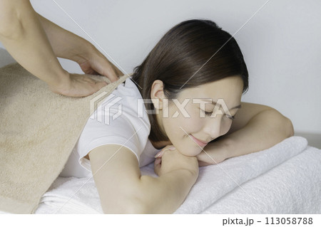 肩をマッサージしてもらう若い女性 肩をマッサージしてもらう若い女性 113058788