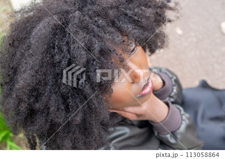 Dreamy Gaze: Upward Looking African American Woman with Voluminous Afro Dreamy Gaze: Upward Looking African American Woman with Voluminous Afro 113058864