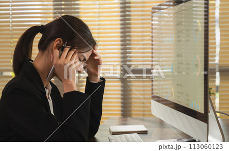 Stressed businesswoman have headaches due to working on a computer screen for a long time. May be office syndrome. Stressed businesswoman have headaches due to working on a computer screen for a long time. May be office syndrome. 113060123