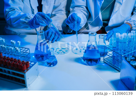 Science and medicine, scientist analyzing and dropping a sample into a glassware, experiments containing chemical liquid in laboratory on glassware, innovative and technology. 113060139