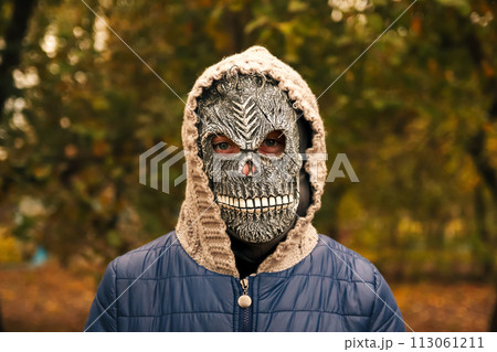 Halloween people portrait. Person in grim reaper mask standing on nature autumn background. Halloween horror. Skull ghost. Grim reaper Halloween people portrait. Person in grim reaper mask standing on nature autumn background. Halloween horror. Skull ghost. Grim reaper 113061211