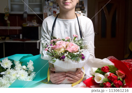 Florist background. A female florist works on a beautiful bouque Florist background. A female florist works on a beautiful bouque 113061216
