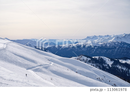 Expansive winter Mountain vista under a pale sky. 113061978
