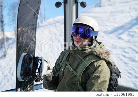 Snowboarder's Gondola Ride to the Top 113061983