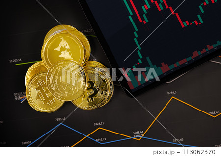 Bitcoin and crypto coins near digital tablet on graph 113062370