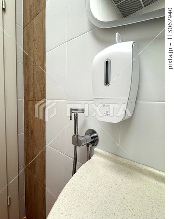 soap dispenser in small public toilet  113062940