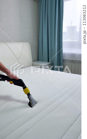 The concept of cleaning and housekeeping. Dry cleaning of the mattress by a professional method. The concept of cleaning and housekeeping. Dry cleaning of the mattress by a professional method. 113063212