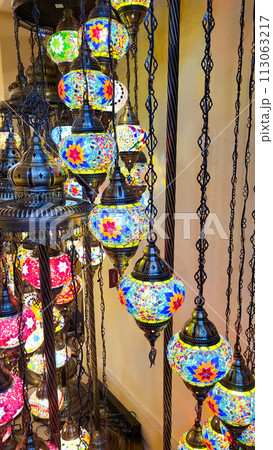 Mosaic of colored glass. Illuminated in the evening, it creates a cozy atmosphere. Vintage multicolored lamps in traditional Oriental style, Arab-style lanterns 113063217