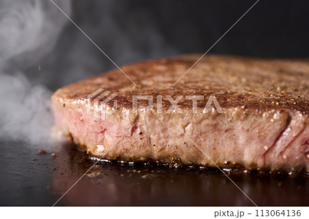 牛もも肉のステーキを鉄板で焼く 牛もも肉のステーキを鉄板で焼く 113064136