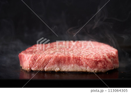 牛もも肉のステーキを鉄板で焼く 牛もも肉のステーキを鉄板で焼く 113064305