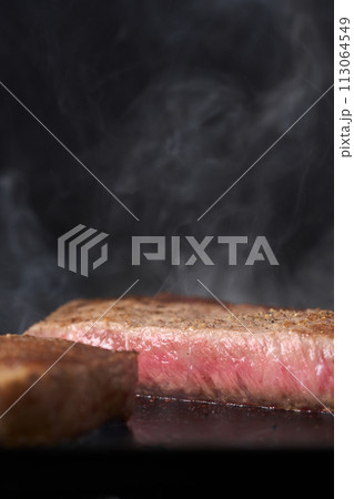 牛もも肉のステーキを鉄板で焼く 牛もも肉のステーキを鉄板で焼く 113064549