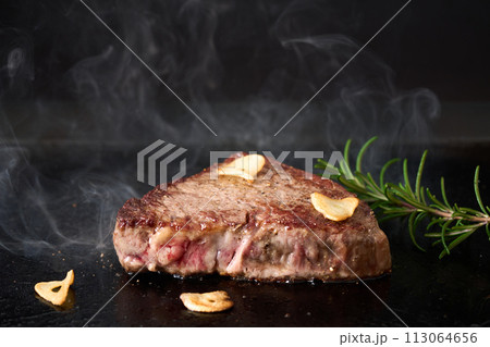 牛もも肉のステーキを鉄板で焼く 113064656