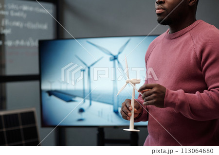 Young male manager with windmill model Young male manager with windmill model 113064680