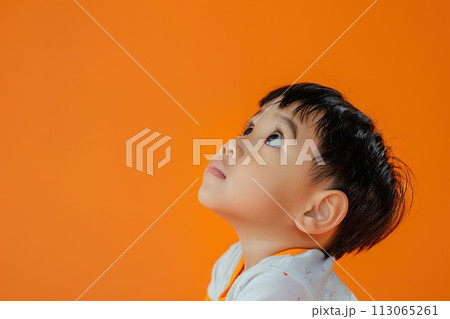 Young Boy Looking Up at Orange Background 113065261