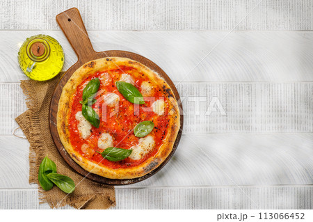Margarita pizza with tomatoes, mozzarella cheese and basil 113066452