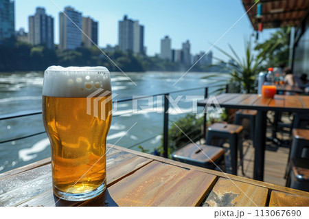 Beer in a glass on the terrace of a restaurant by the river 113067690