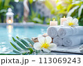 Spa composition with towels and flowers at poolside 113069243