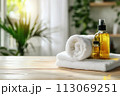 Spa treatment accessories, towels and oil bottles on wooden background 113069251