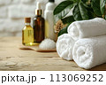 Spa treatment accessories, towels and oil bottles on wooden background 113069252