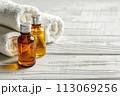 Spa treatment accessories, towels and oil bottles on wooden background 113069256