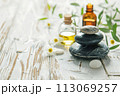 Beautiful spa composition with stones and oil bottles on wooden background 113069257