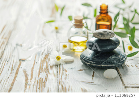 Beautiful spa composition with stones and oil bottles on wooden background 113069257