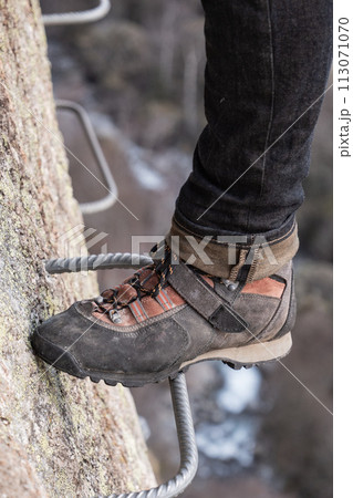 Man in body harnesses feature life-safety, viaferrata in mountains of pyrenees Man in body harnesses feature life-safety, viaferrata in mountains of pyrenees 113071070