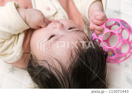 【指しゃぶりする赤ちゃんとおもちゃ】 113071443