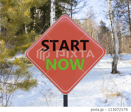 Start now symbol. Concept words Start now on beautiful red road sign. Beautiful forest snow blue sky background. Business marketing, motivational start now concept. Copy space. 113072579