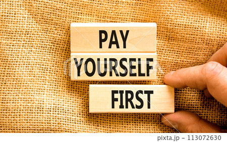 Pay yourself first symbol. Concept words Pay yourself first on beautiful wooden blocks. Beautiful canvas table canvas background. Businessman hand. Business and pay yourself first concept. Copy space. Pay yourself first symbol. Concept words Pay yourself first on beautiful wooden blocks. Beautiful canvas table canvas background. Businessman hand. Business and pay yourself first concept. Copy space. 113072630