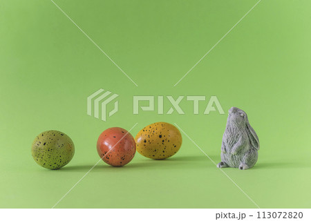 Happy Easter holiday greeting card template; easter eggs and rabbit on a green background; copy space 113072820