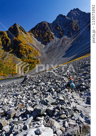 紅葉の北アルプス・涸沢カールを行く登山者と前穂高岳北尾根 113073892