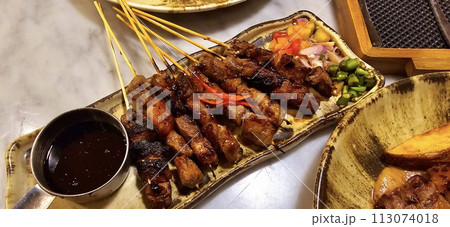 Homemade beef Satay marinated with spice and sweet soy sauce, coriander beef satay, served on plate with onion, chilli, soy sauce and tomato Homemade beef Satay marinated with spice and sweet soy sauce, coriander beef satay, served on plate with onion, chilli, soy sauce and tomato 113074018